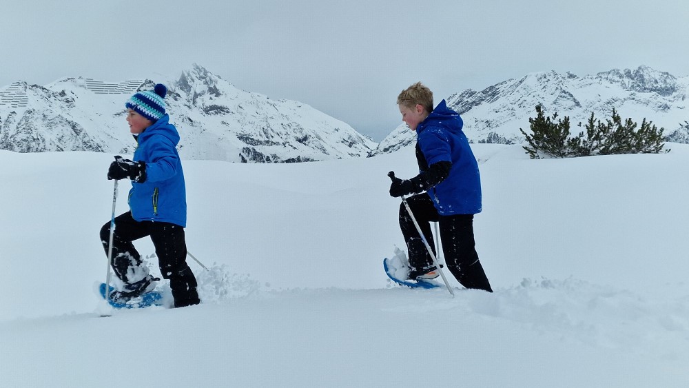 Sneeuwschoenwandelen met kids hoog op de berg.